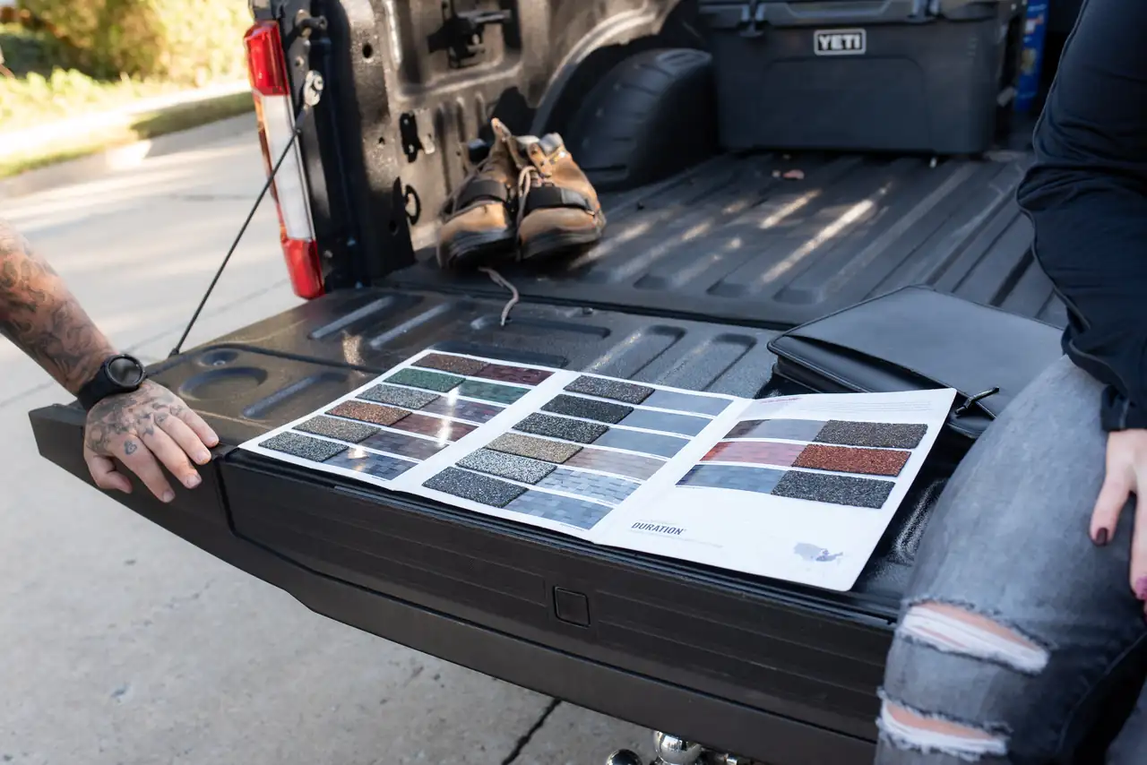 Shingle color samples laid out on a truck tailgate for a homeowner to choose from